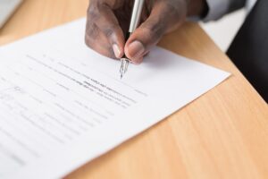 A man signing a contract for hiring a moving company .