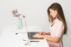 A girl looking up ways to save office space when packing supplies on her laptop.