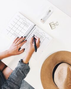 A girl writing her future plans in a planner before moving into her college dorm