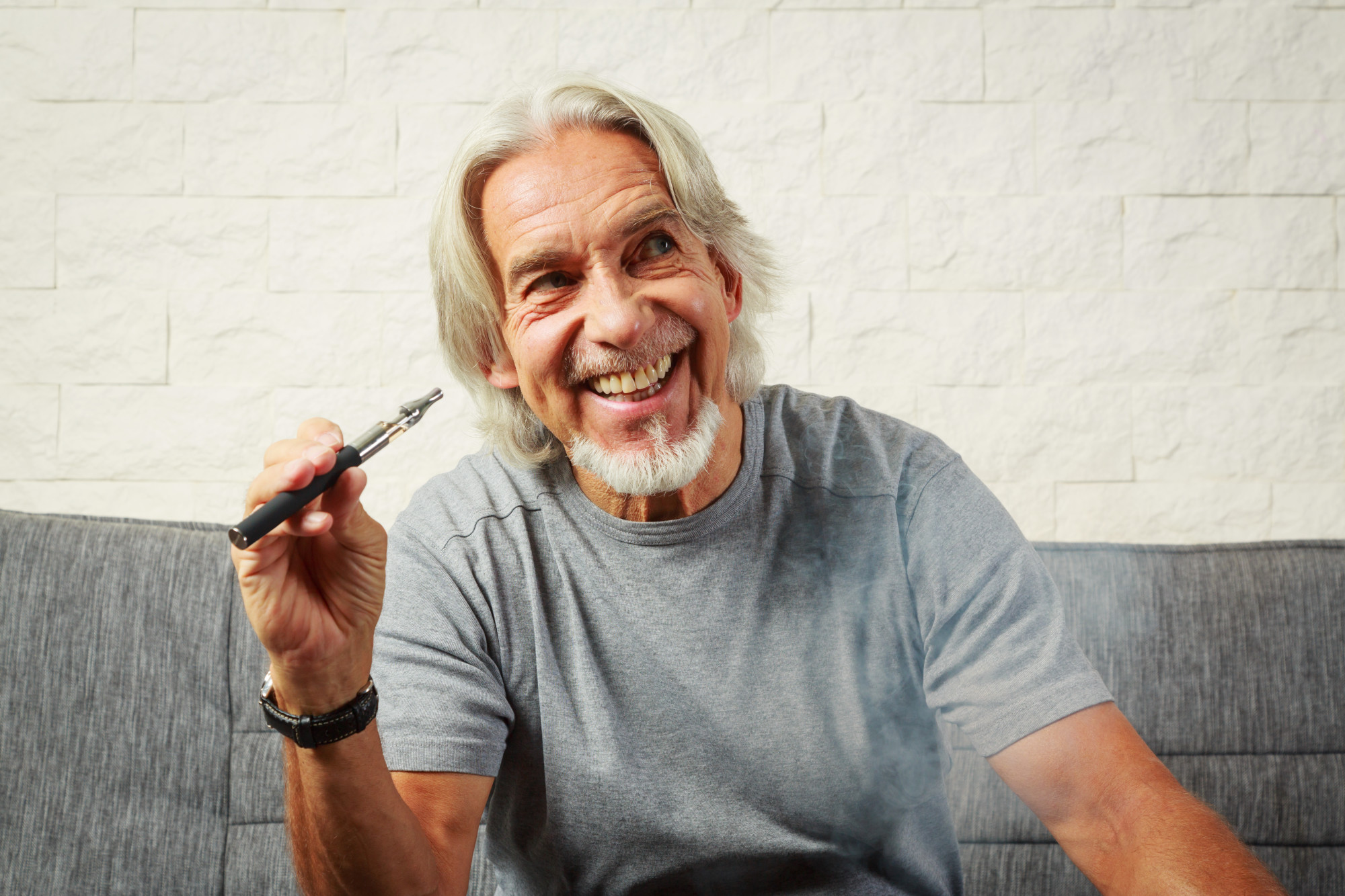 Senior man vaping, enjoying an electronic cigarette