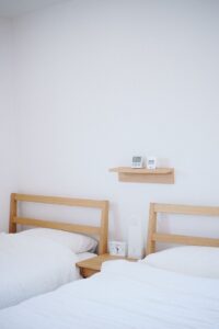 Two beds in a college dorm that's move-in ready with clean sheets
