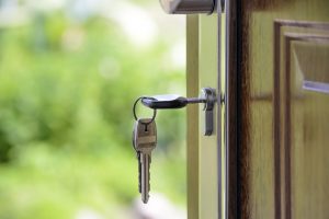 The keys in the lock of an open house door.