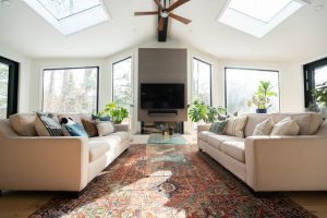 A living room with a white sofa and a traditional rug