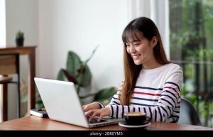 Lady using laptop inside house