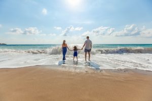 A family on a beach looking at the sea