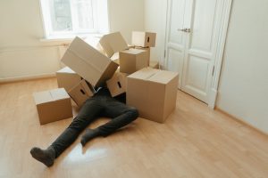 A man under a pile of boxes.