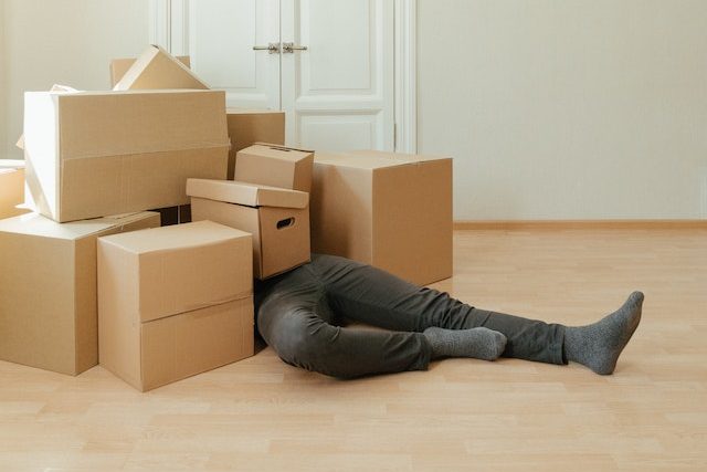 a man laying under cardboard boxes