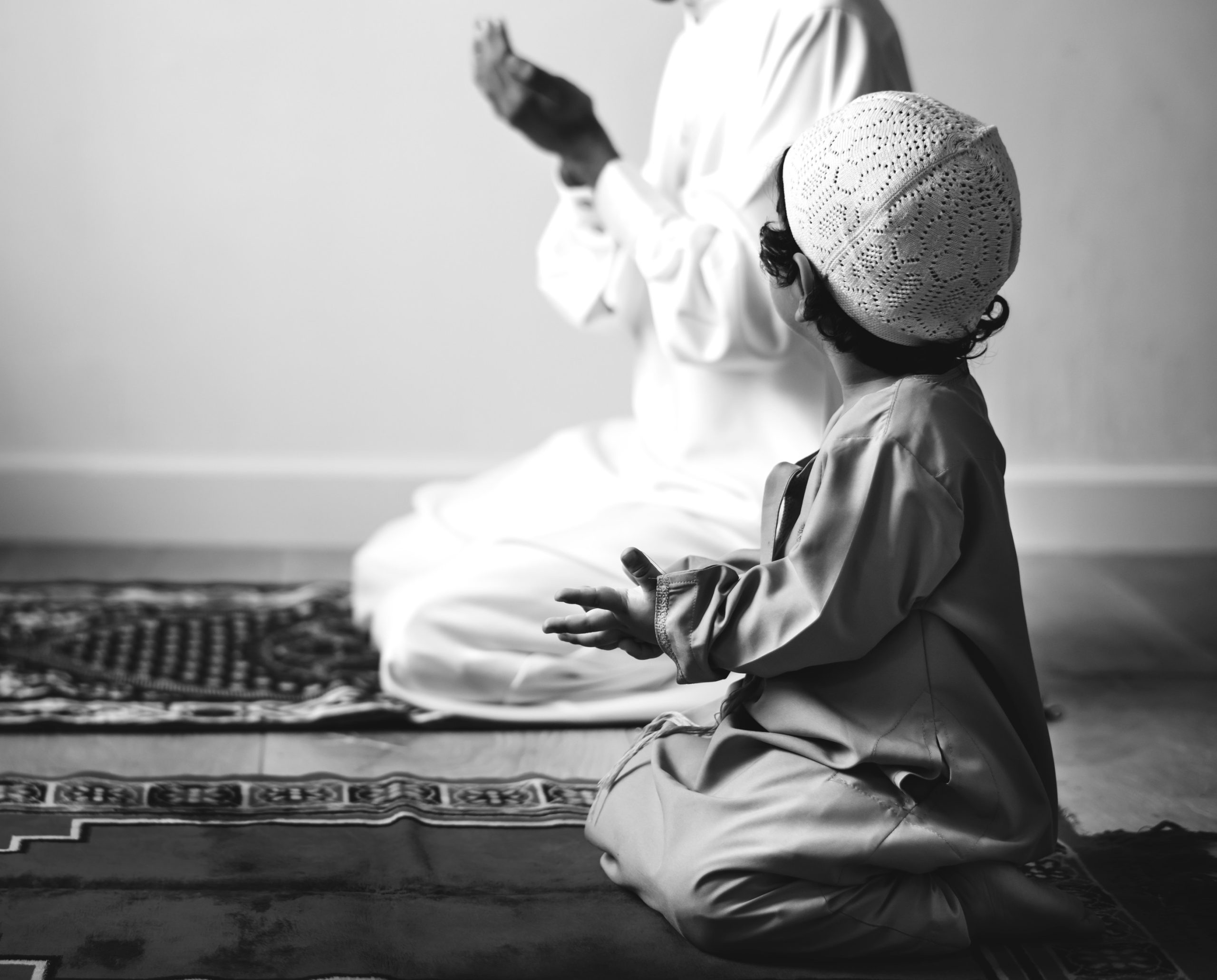 men perform prayer with son